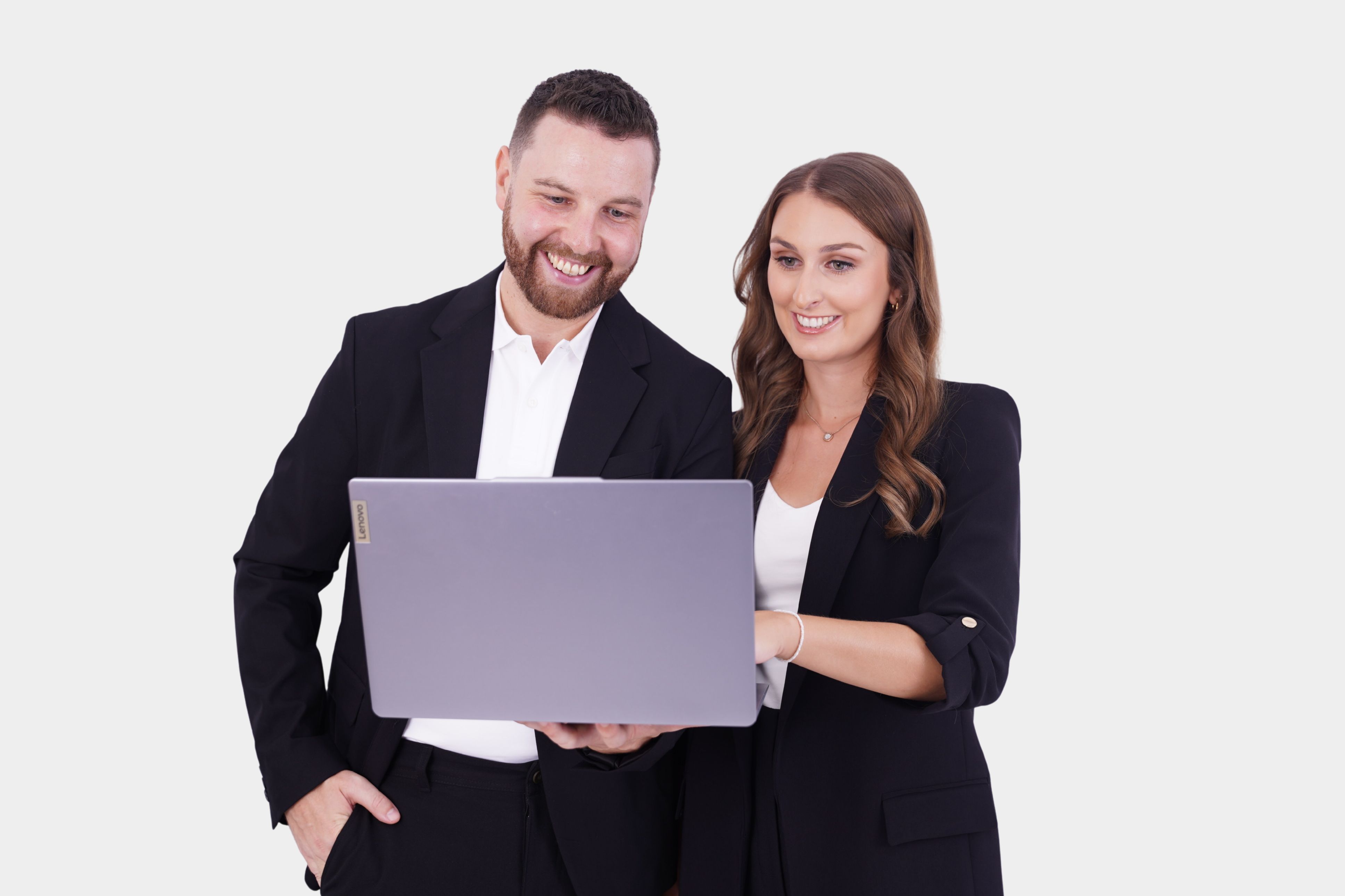 Ein Mann und eine Frau in Business-Kleidung schauen gemeinsam auf einen Laptop und lächeln. Sie arbeiten als Digital CFO bei der Corporate Finance Manufaktur in Innsbruck.